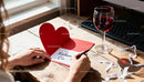 Writing a heartfelt love message in a red card at home