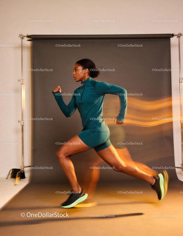 Energetic woman sprinting indoors in athletic outfit