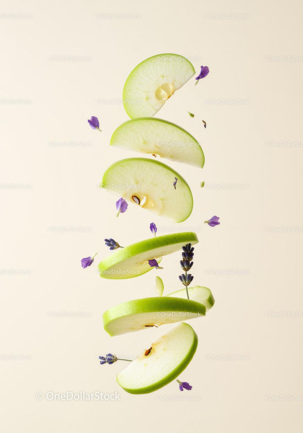 Floating green apple slices with delicate purple flowers