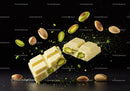 Broken white chocolate bar with pistachios in midair