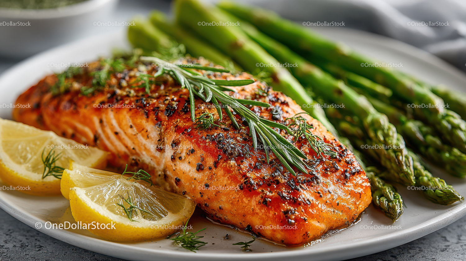 Grilled Salmon with Asparagus and Lemon Slices on a White Plate