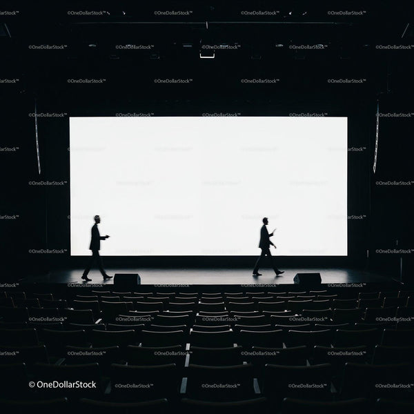 Silhouettes of Speakers Crossing Stage in Dark Auditorium JPG Mockup Image