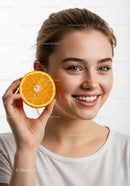 Bright Young Woman Smiling While Holding a Fresh Orange Slice