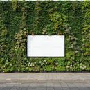 Blank white billboard on vibrant green living wall