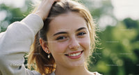 Young Woman Smiling Outdoors on Sunny Day with Green Background