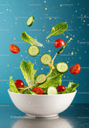 Fresh salad ingredients tossed in white bowl with dressing