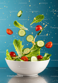 Fresh salad ingredients tossed in white bowl with dressing