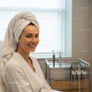 Young Woman Smiling with Towel on Head During Spa Facial Treatment