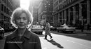 Elderly Woman in Busy City Street Surrounded by Vintage Cars