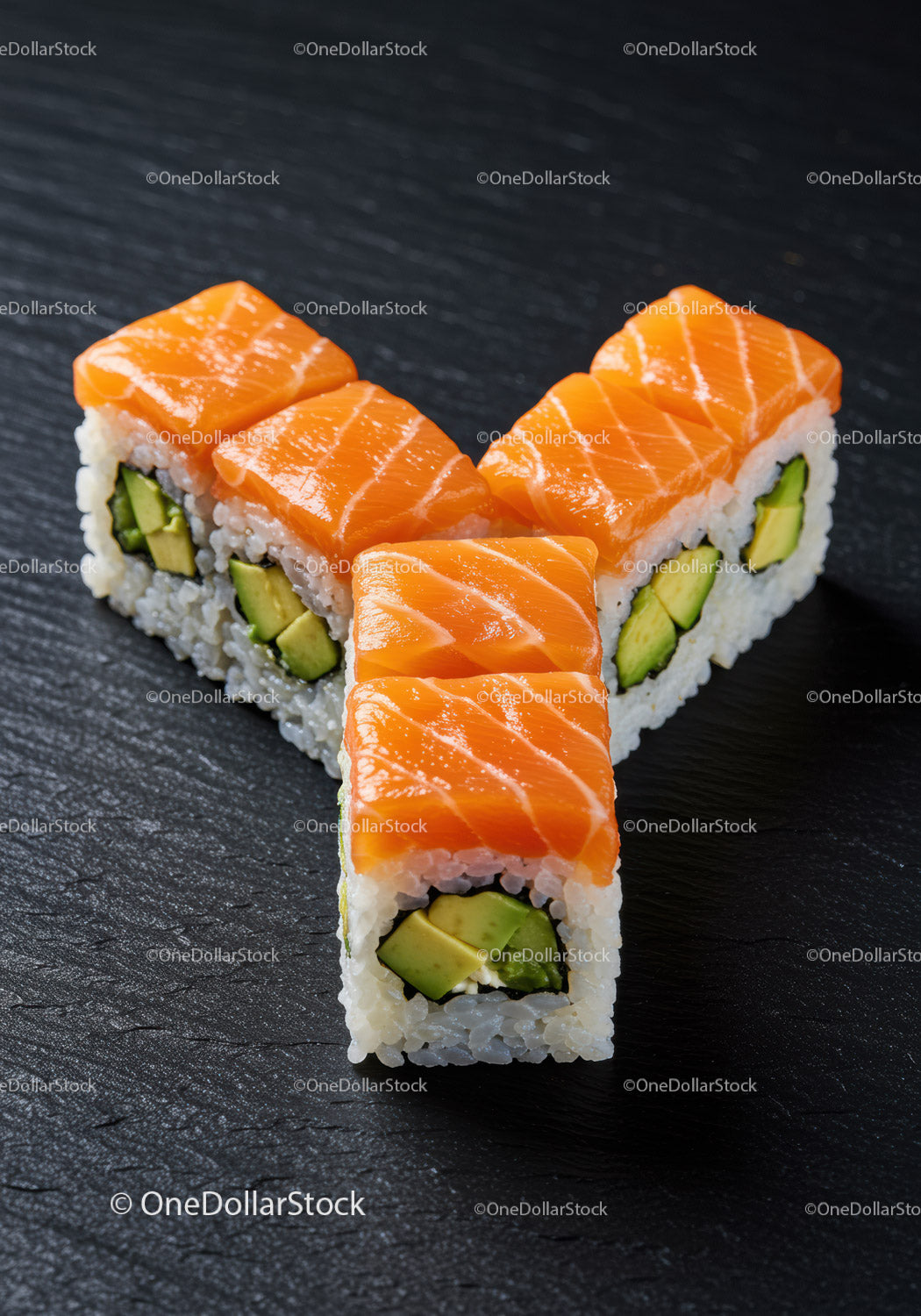 Świeże rolki sushi z łososiem i awokado na ciemnej powierzchni