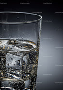 Clear glass of sparkling water with ice cubes closeup