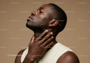 Close-up of a Young Black Man Touching His Chin and Neck with Skincare Focus