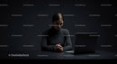 Thoughtful Woman at Laptop in Dark Modern Workspace