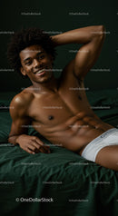 Relaxed young man lying on bed smiling confidently