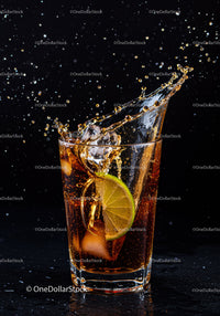 Refreshing iced cola splash with lime slice in glass