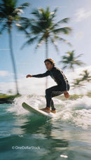 Man surfing with tropical palm trees in the background