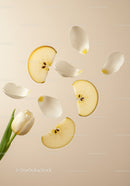 White tulip with floating apple slices and petals