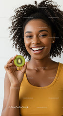 Vibrant Young Woman with Curly Hair Holding Kiwi Fruit Smile