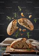 Rustic bread breaking apart with fresh rosemary herbs
