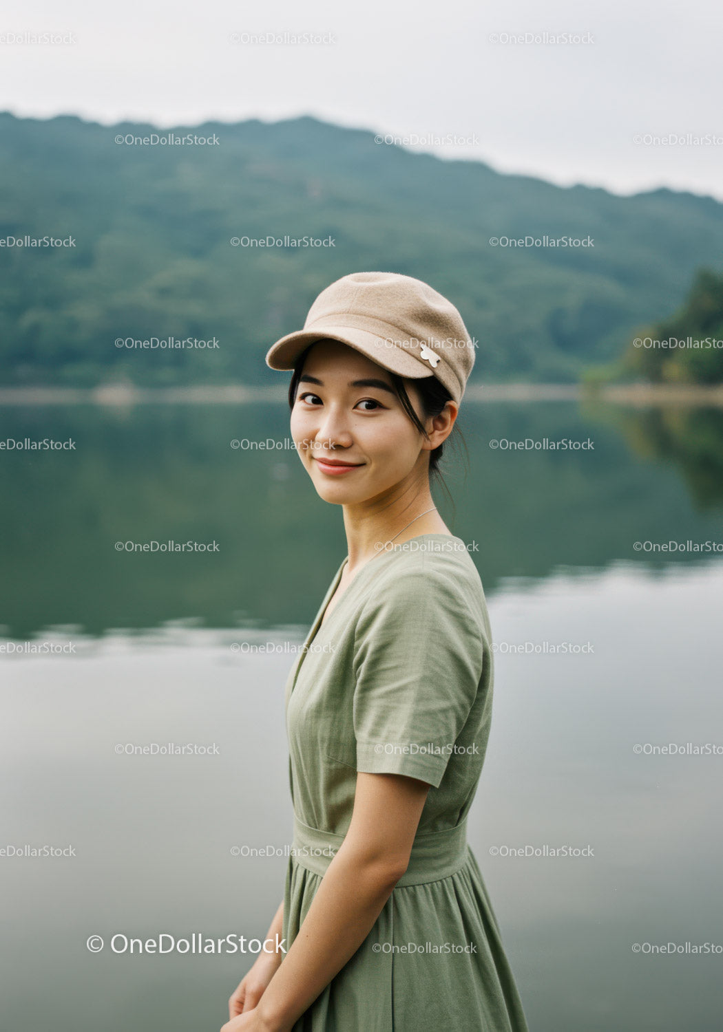 Young Woman in Green Dress Wearing Beige Cap Near Lake Landscape