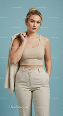 Elegant Woman in Beige Crop Top and Cream Trousers Studio Portrait
