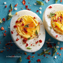 Sliced Hard Boiled Eggs with Chili Flakes and Herbs on Blue Background