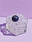 Single Blueberry Resting on Sparkling Ice Cube