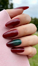 Long glossy nails painted in deep red and green shades