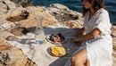 Woman enjoying fresh figs and citrus by the sea