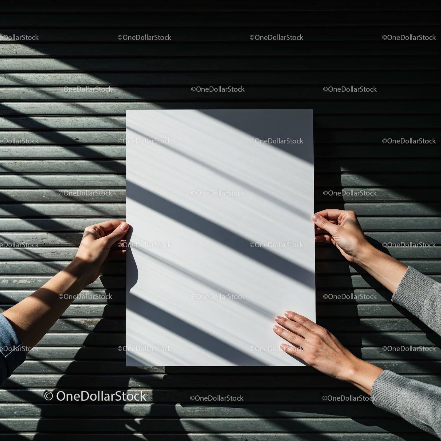 Hands Holding Blank Paper Against Textured Metal Surface