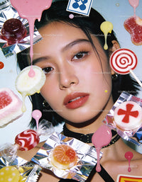 Young woman surrounded by colorful assorted candies