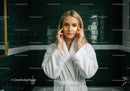 Woman in White Bathrobe Applying Gold Under-Eye Patches in Spa