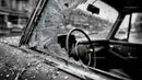 Abandoned Vintage Car with Broken Glass at Sunset