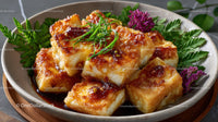 Crispy Fried Tofu with Savory Sauce Garnished with Fresh Herbs and Flowers