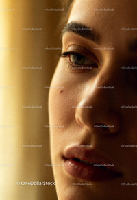 Close-up of thoughtful young woman’s face in warm light
