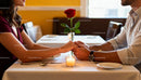 Couple Holding Hands Over Romantic Dinner Table
