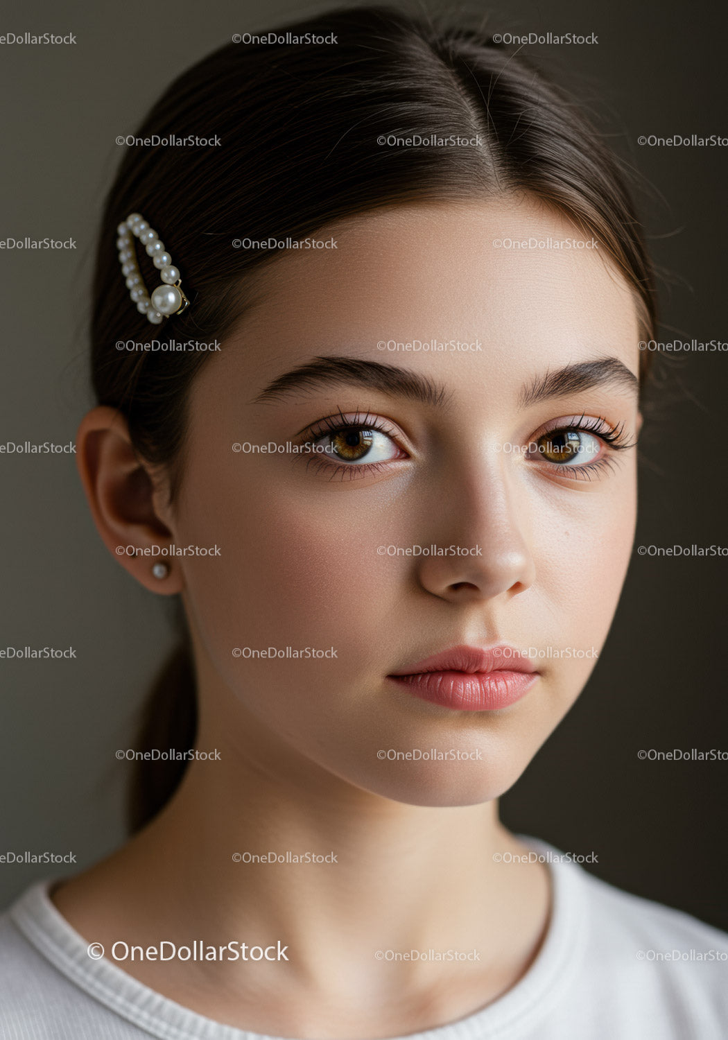 Elegancka młoda kobieta z perłową spinką do włosów i naturalnym makijażem
