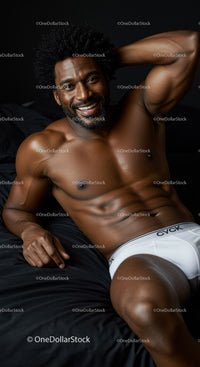 Smiling muscular man relaxing on black bed in white underwear