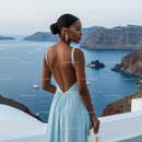 Elegant woman in blue dress overlooking coastal cliffs