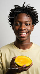 Young Man Holding Yellow Mango Smiling Cheerfully
