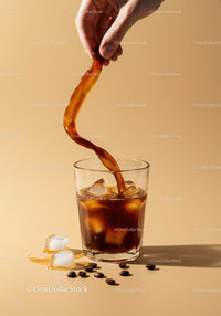 Pouring Iced Coffee into Glass with Ice Cubes