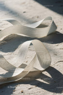 Close-up of White Plastic Ribbon Waste on Sandy Beach