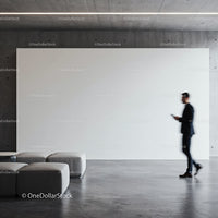 Businessman walking by blank modern gallery wall