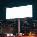 Illuminated blank billboard in urban cityscape at night