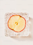 Top view of apple slice frozen in clear ice cube