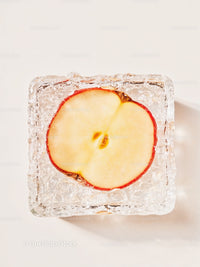 Top view of apple slice frozen in clear ice cube