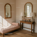 Cozy corner with pink chaise lounge and wooden console
