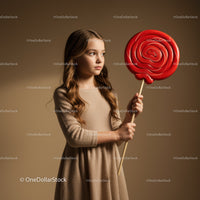 Young girl holding giant red lollipop on beige background
