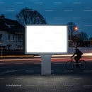 Blank illuminated billboard at night on urban street