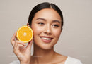 Women Smiling with Fresh Orange Half for Natural Skin Glow